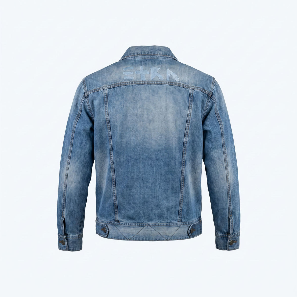 Back view of the unconventionally constructed ETRN denim jacket, demonstrating the structured streetwear fit and engineered tailoring for men. Features the brand name 'ETRN' printed across the upper back.