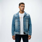 A male model styling the ETRN engineered light blue denim jacket over a white graphic t-shirt and dark blue  jeans for an edgy, premium streetwear look.