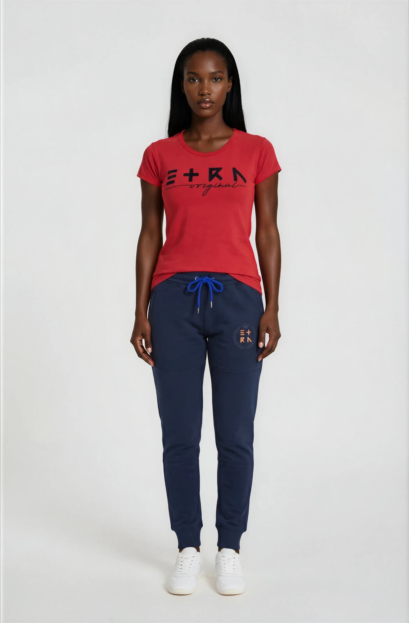 Woman wearing a red t-shirt and navy blue pants on a white background