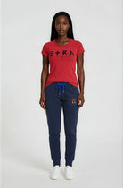 Woman wearing a red t-shirt and navy blue pants on a white background