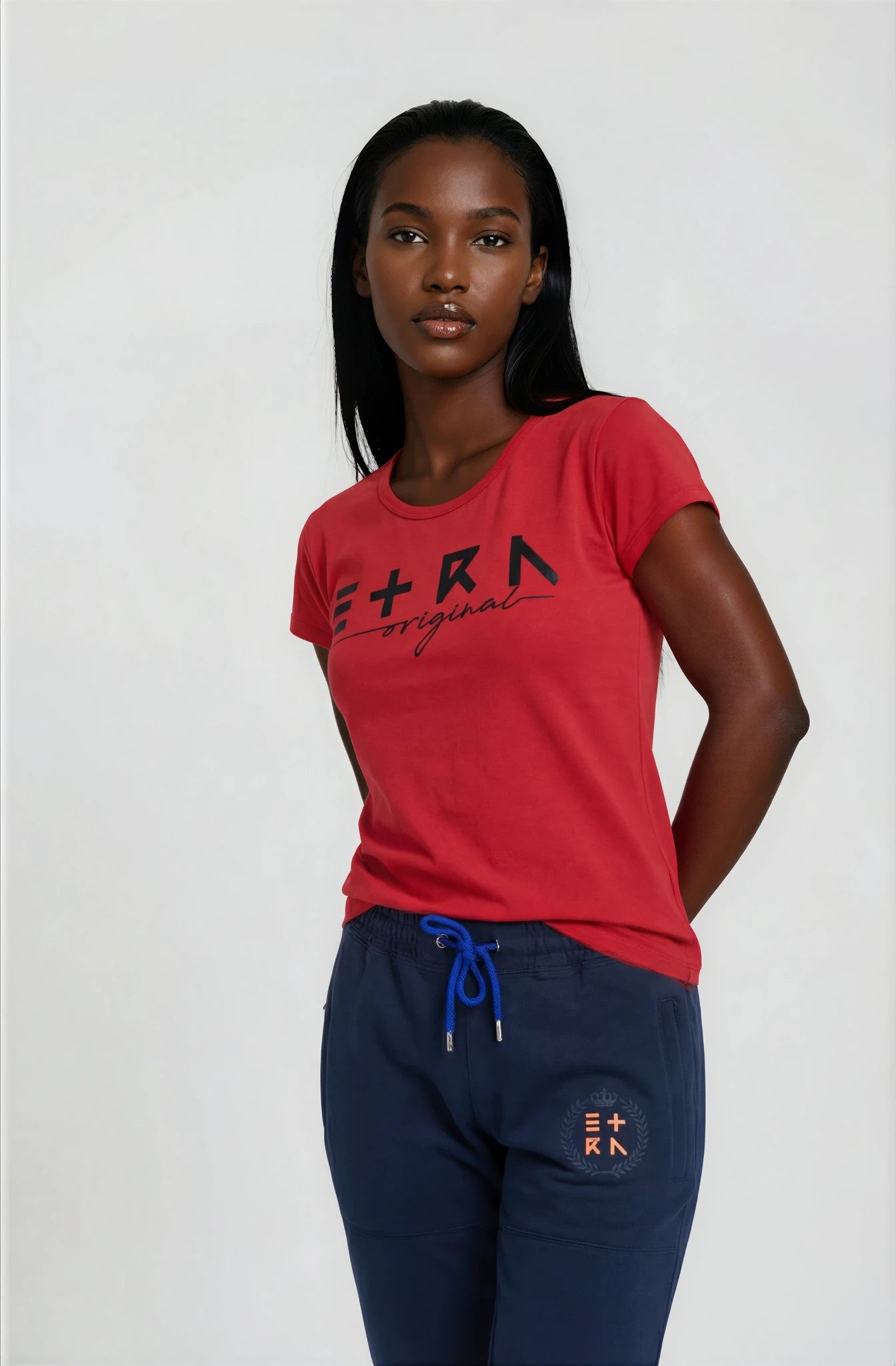 Woman wearing a red 'ETRN' t-shirt and navy pants - Front View